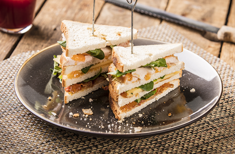 Club sandwich met gerookte kip, oude kaas, bacon en Hero Abrikozen Jam 